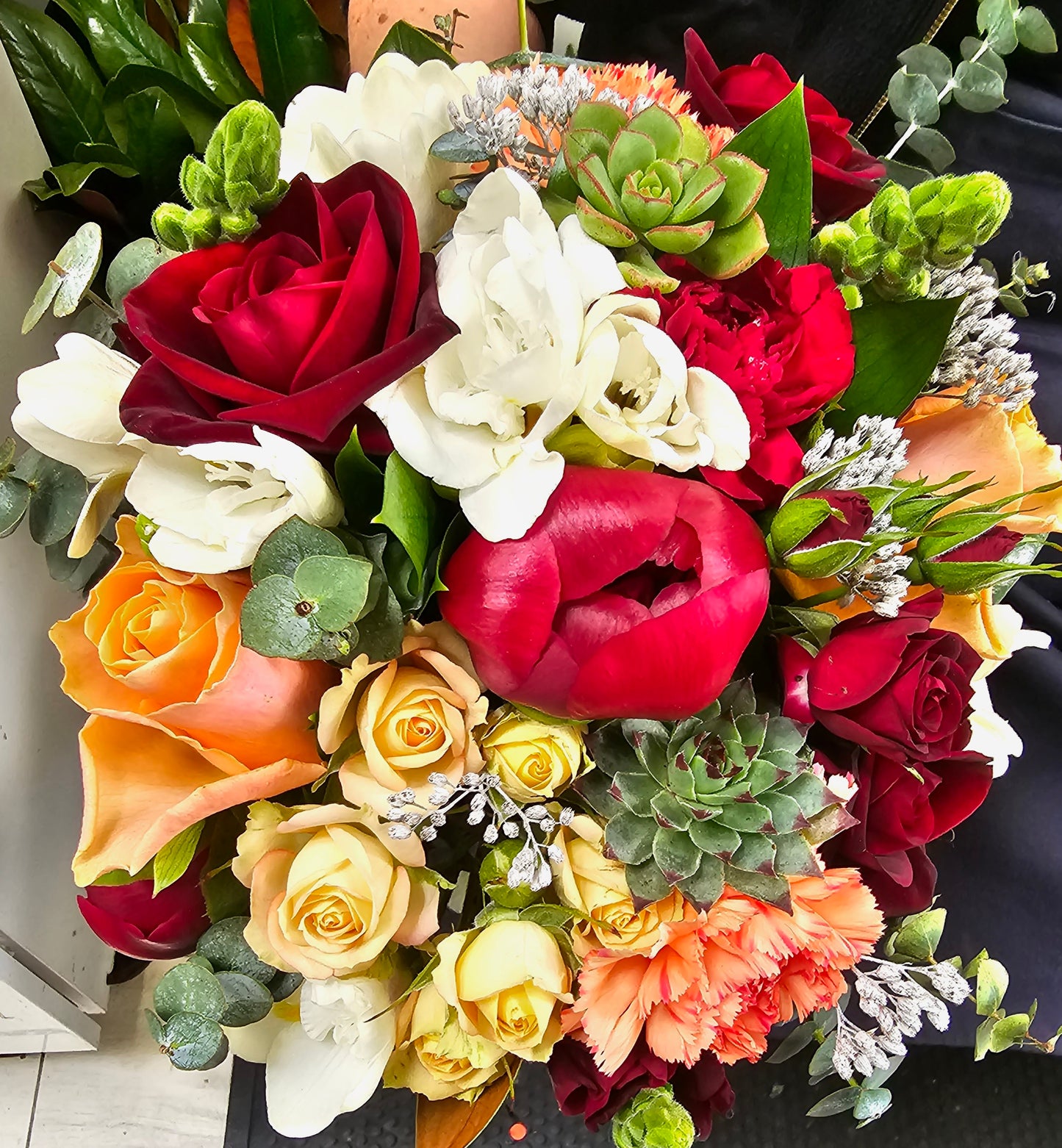 interesting flowers, red and apricot roses, red peony, freesias, suculents, baby gum