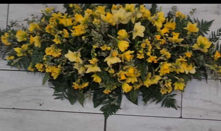casket spray made with a varriety of daffodils and jonquils