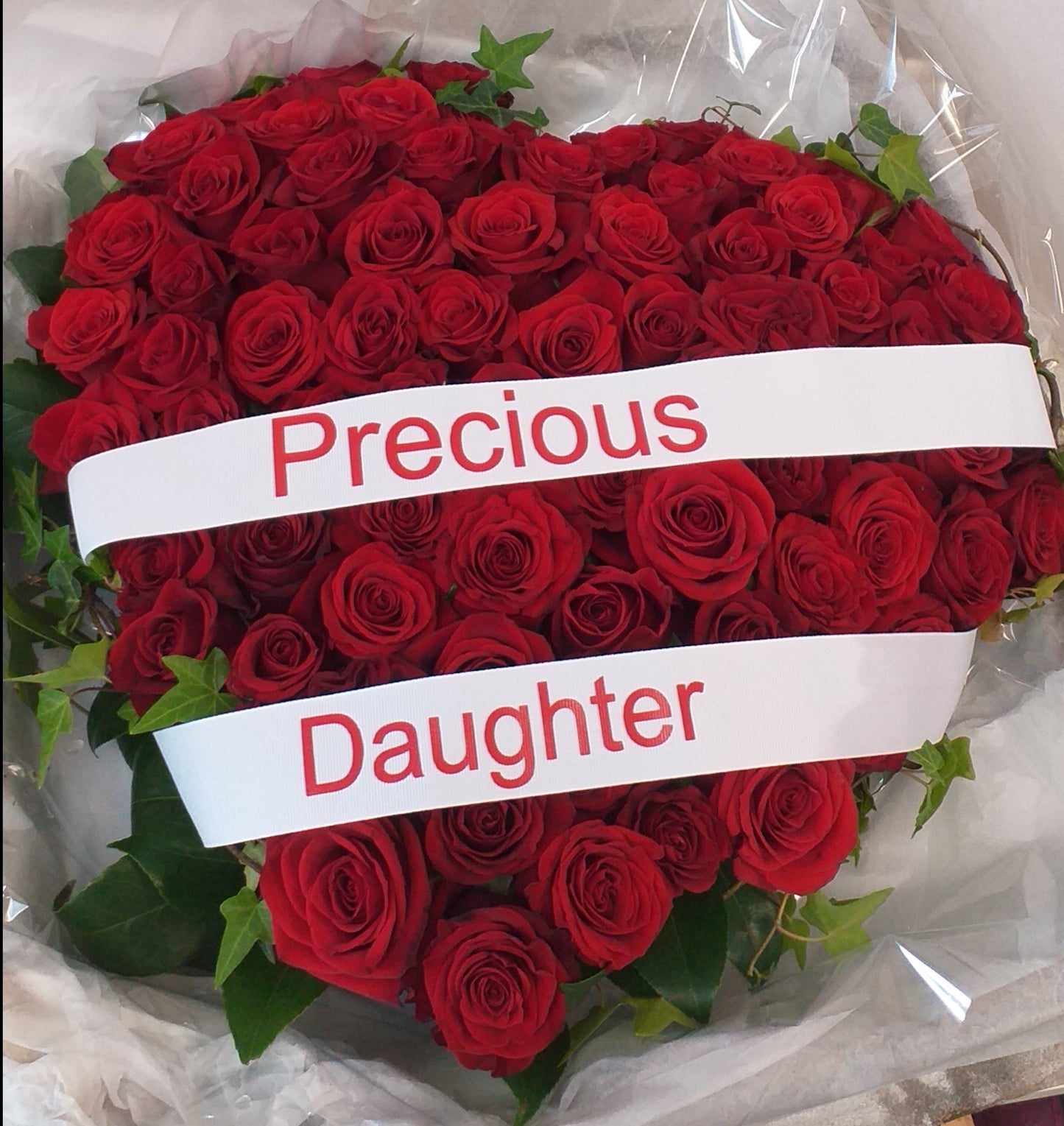 a casket pillow in a heart shape made with red roses