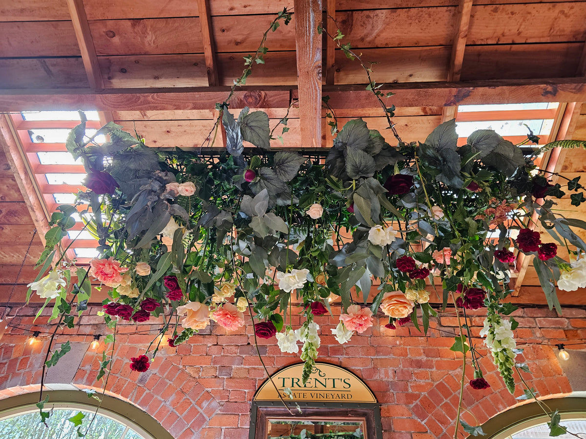 reception ceiling arrangement of roses carnations antirrinum, freesia and bluegum leaves