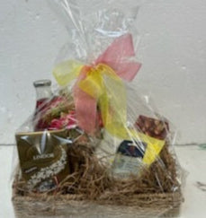Gift basket, pamper pack with chocolates, hand cream, hanky, silk flower posy and a bottle of fruit juice,