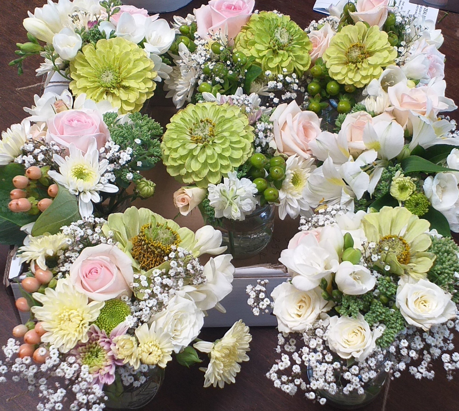 reception decoration for tables in a small vase, roses, chrysies, zinnia, berries, gyp