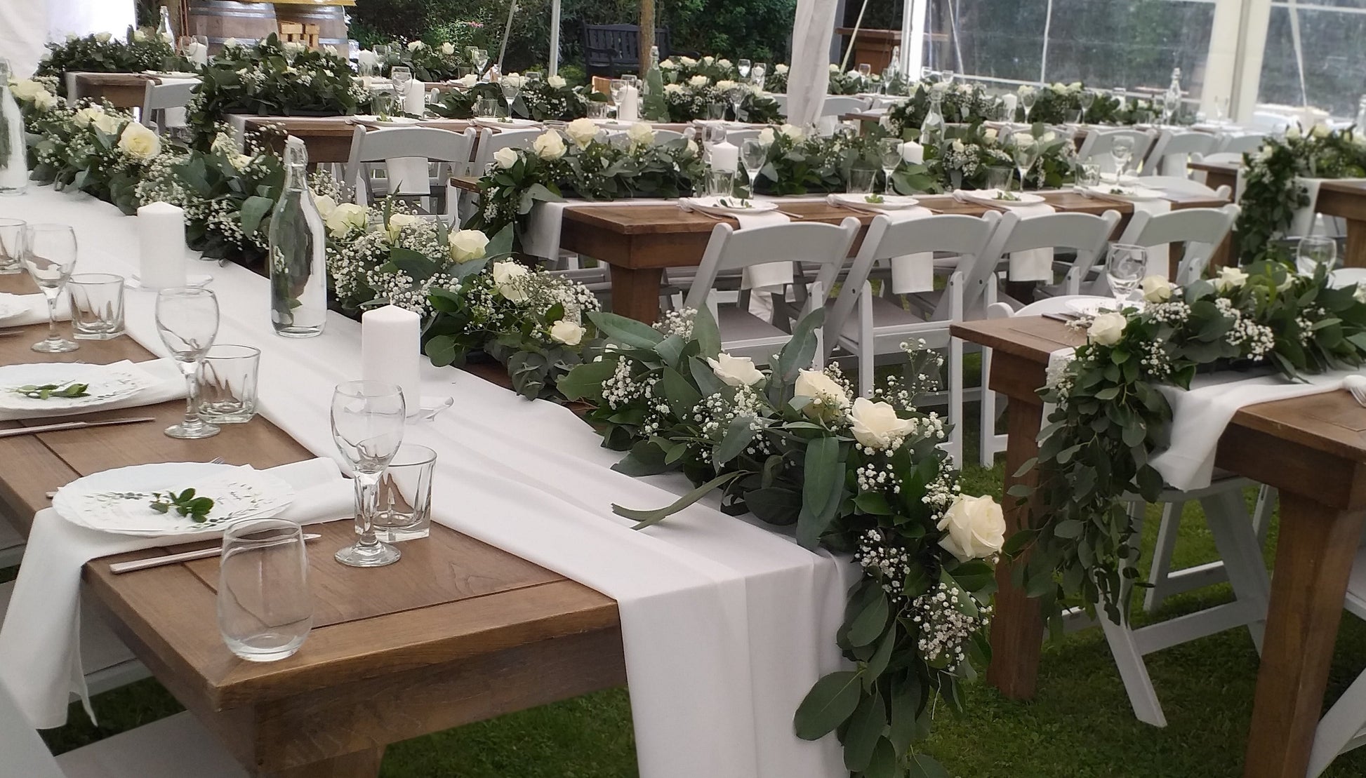 Reception table decorations, gum leaves laid down the center of the tables decorated with gypsophilla and white roses