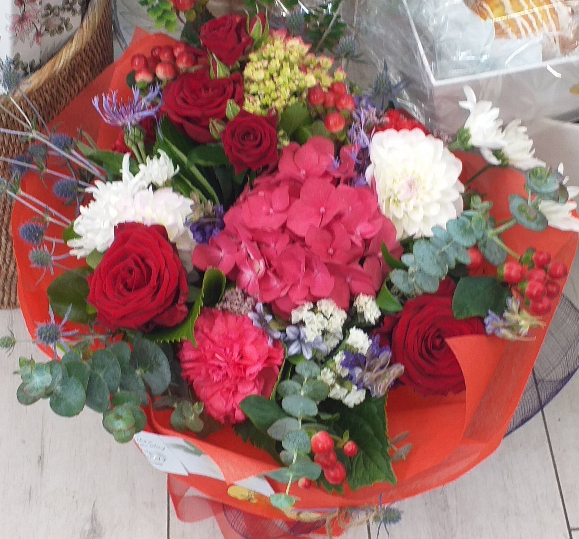 Flower bouquet in colours of red and white, carnation, roses, hydrangea (when in season) berries and gum