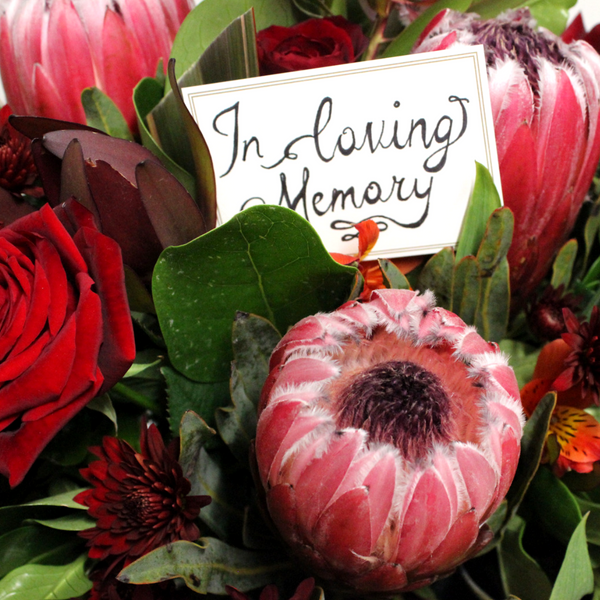 Casket Spray in reds and pinks including roses and proteas