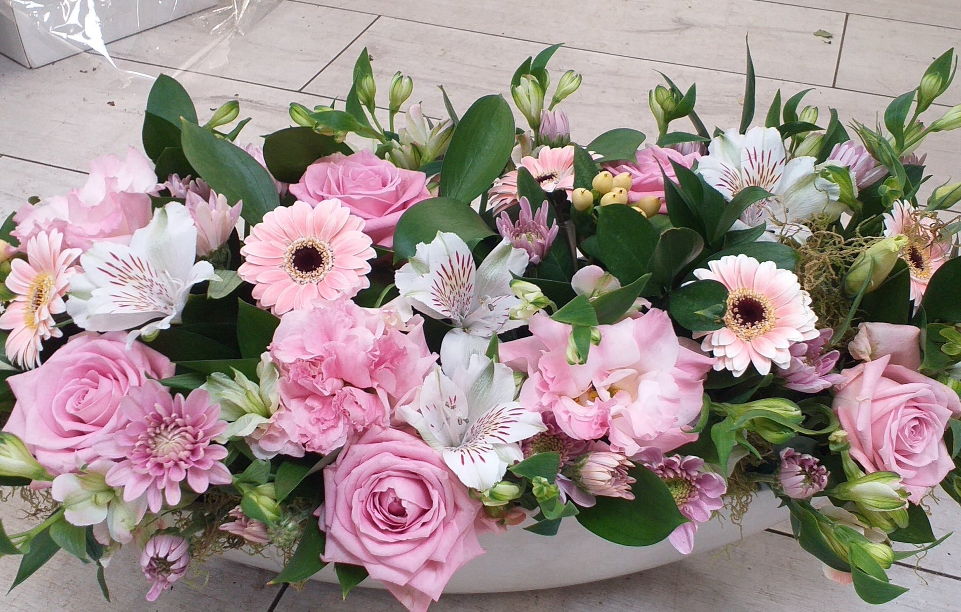 Trough arrangement, withpale pink roses, pale pink gerbera, white alstromeria, berries, spray chrysanthemums,. suitable for decorating a table, mantle piece, entrance table, display table.