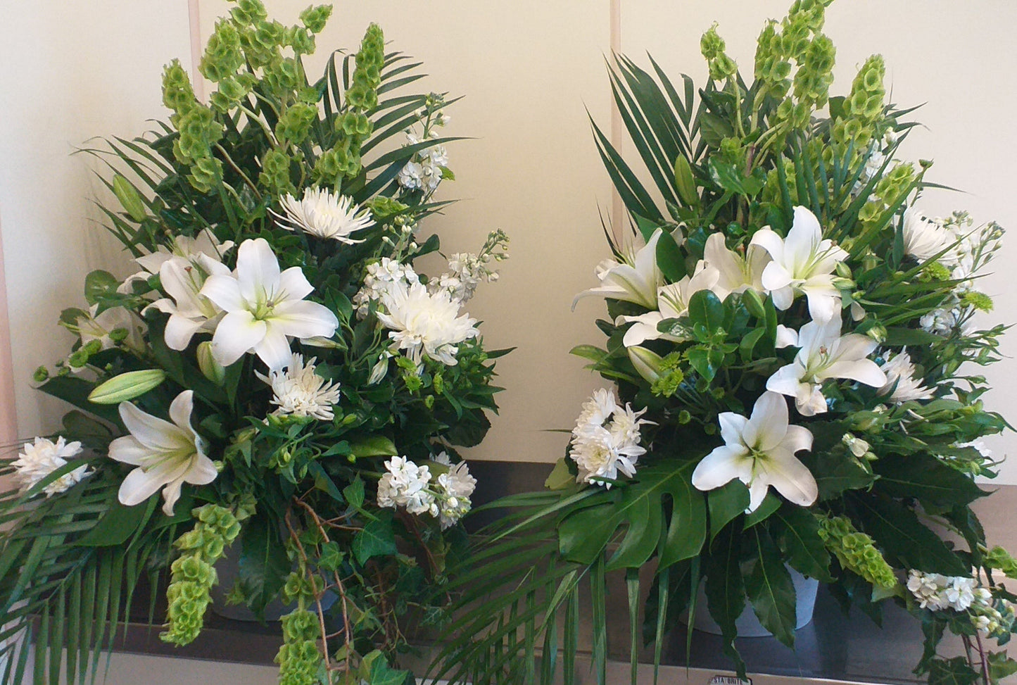 Arrangement with white lilies, chrysies, stock green balm and leaves