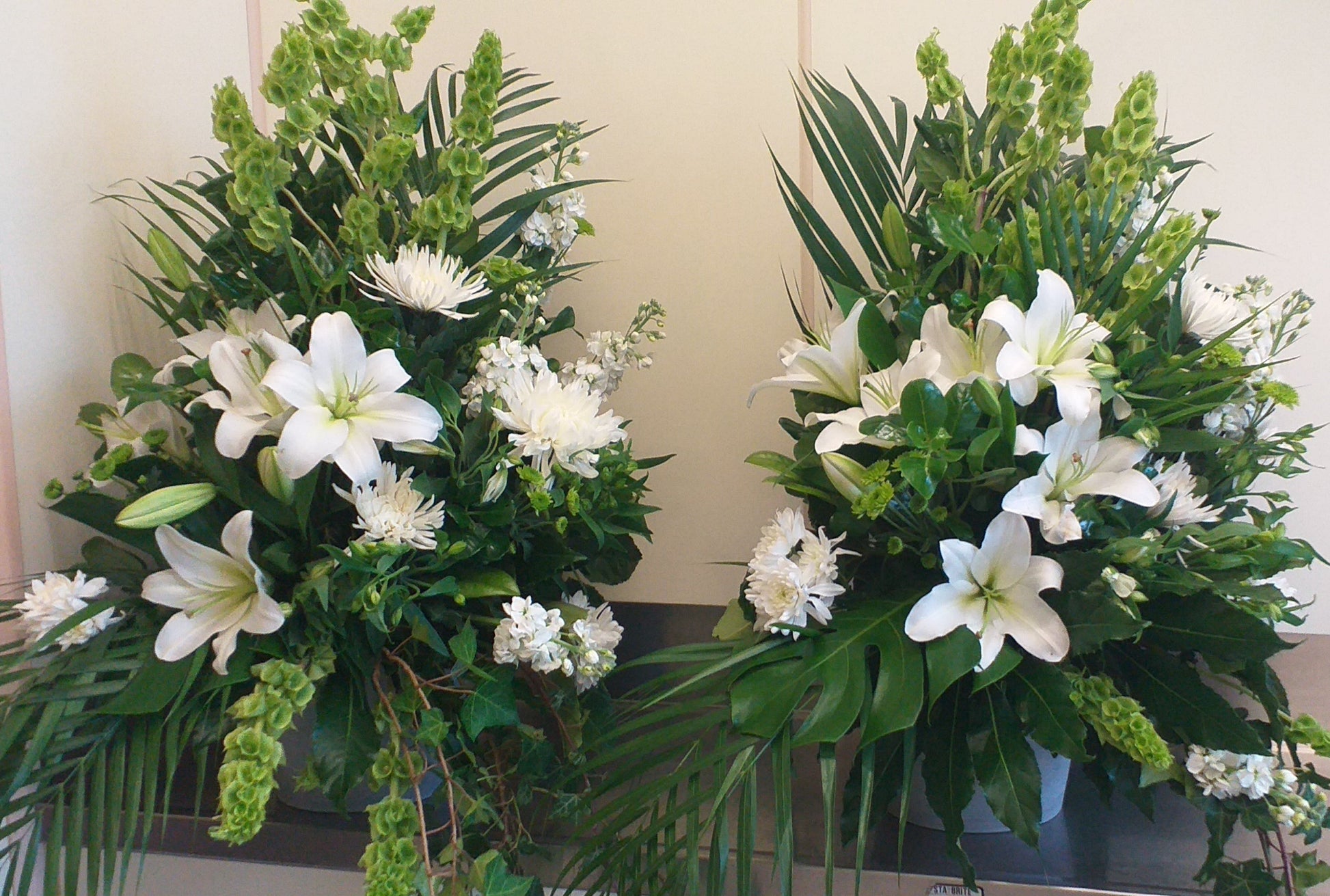 Arrangement with white lilies, chrysies, stock green balm and leaves