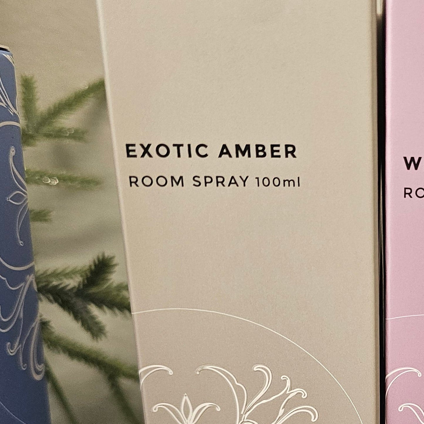 A pink box labeled 'White Orchid' and a beige box labeled 'Exotic Amber'  room spray