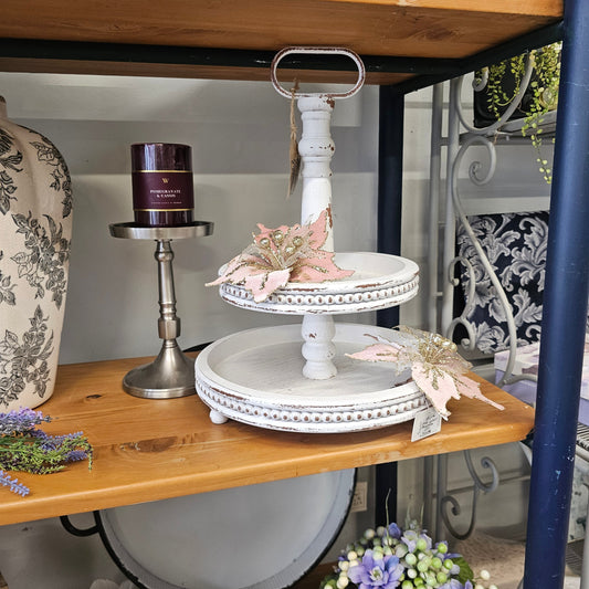 A rustic two-tiered white wooden serving stand 
