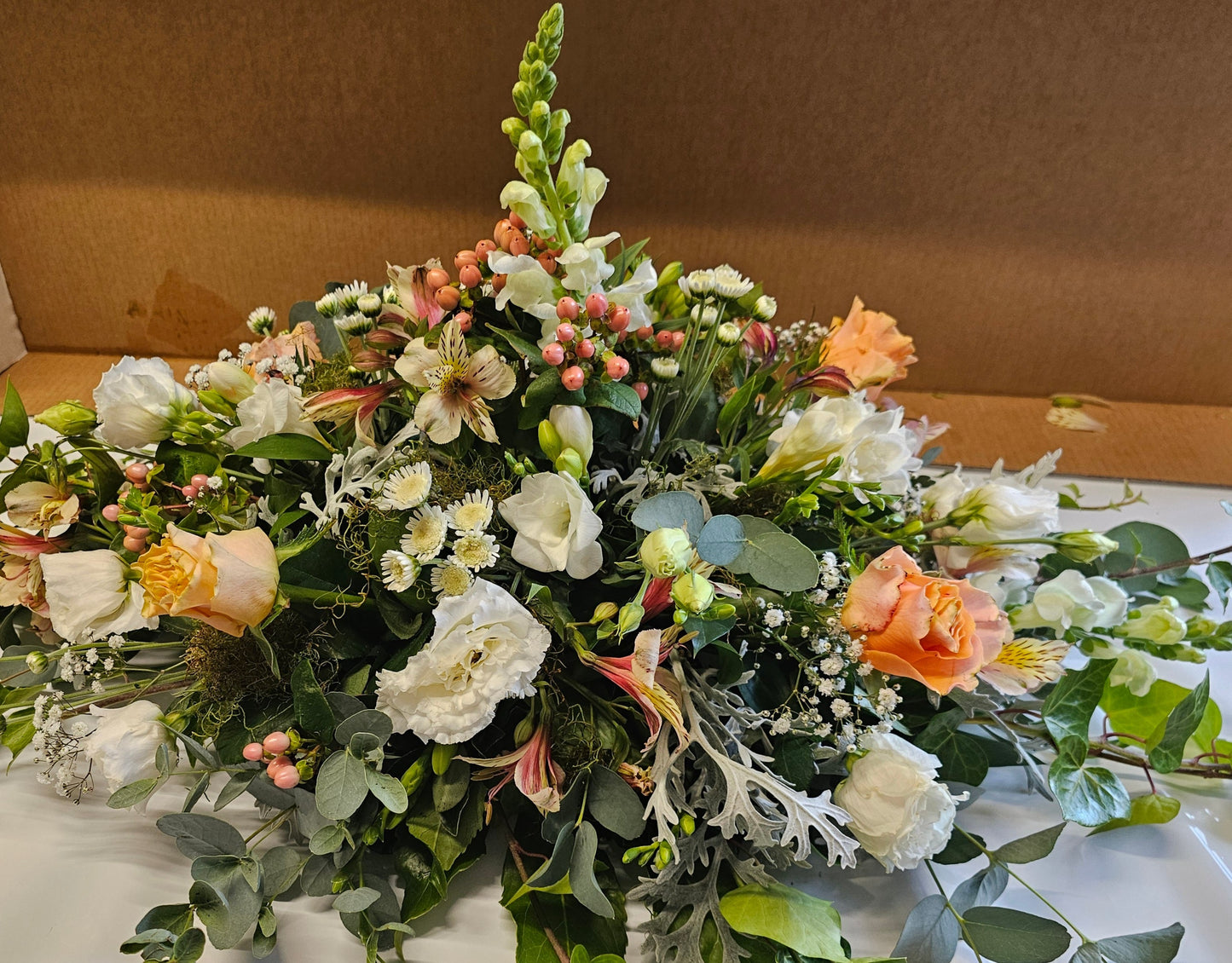 Small casket spray made with roses, antirinums, freesias, alstromeria, gyp, chrysies, 