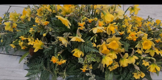 Casket spray made from a variety of daffodils and jonquils