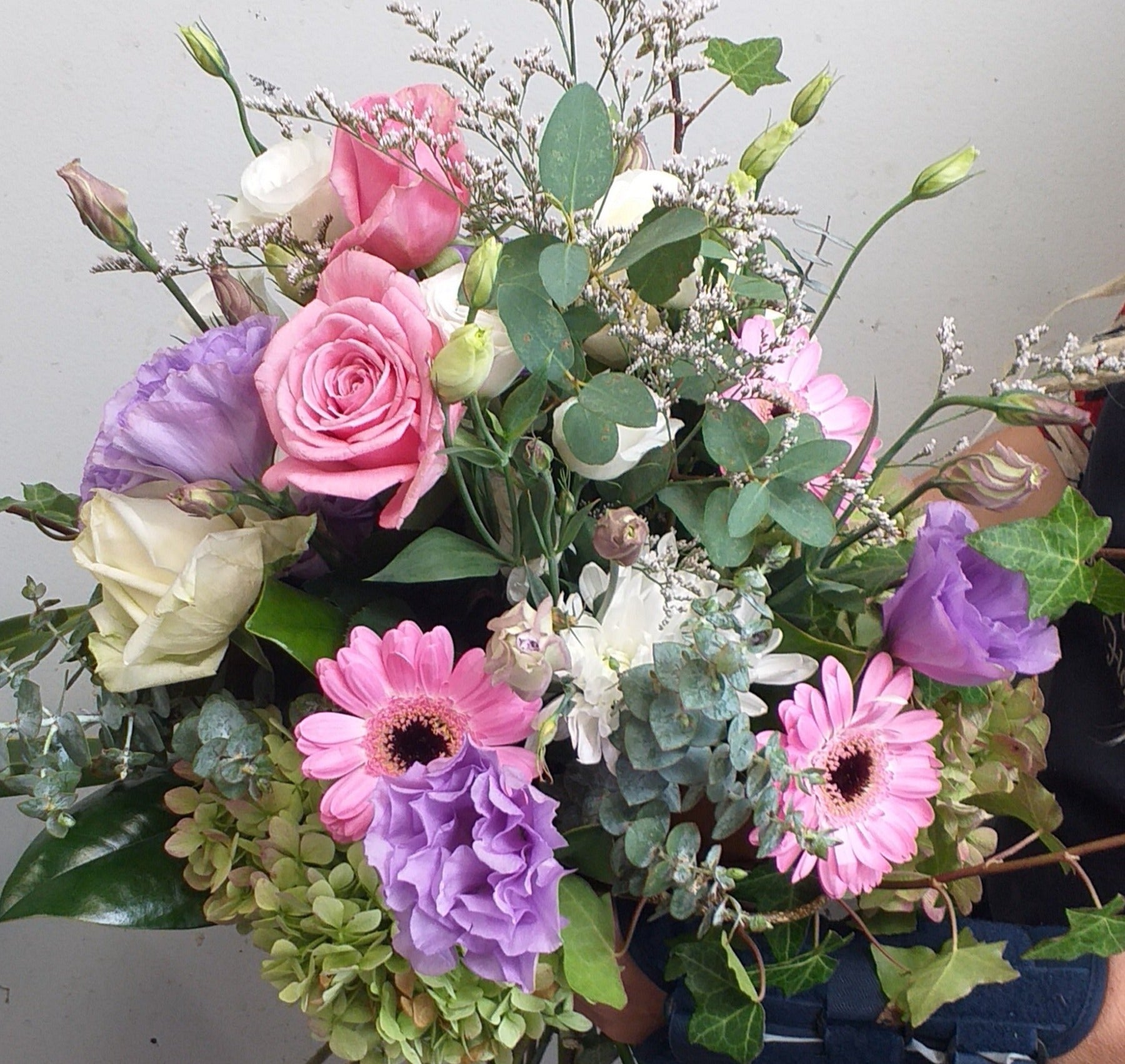whimsical bouquet with roses, gerberas, gum, lisianthus, ivy and limonium, 