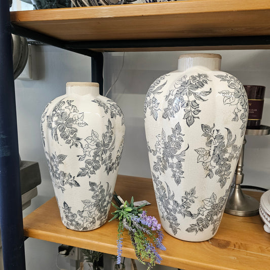 Two ceramic vases with a gray floral toile pattern on an off-white background