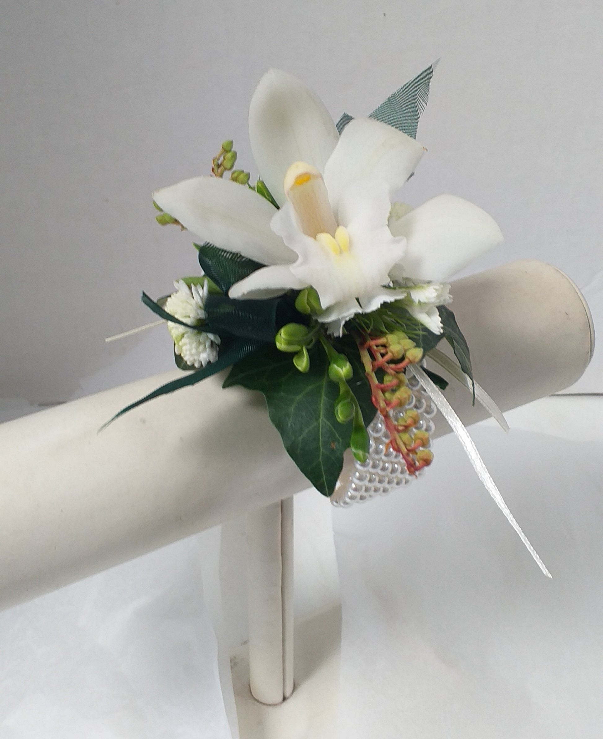 this wrist corsage made from fresia buds ivy leaves pieris and a mini orchid