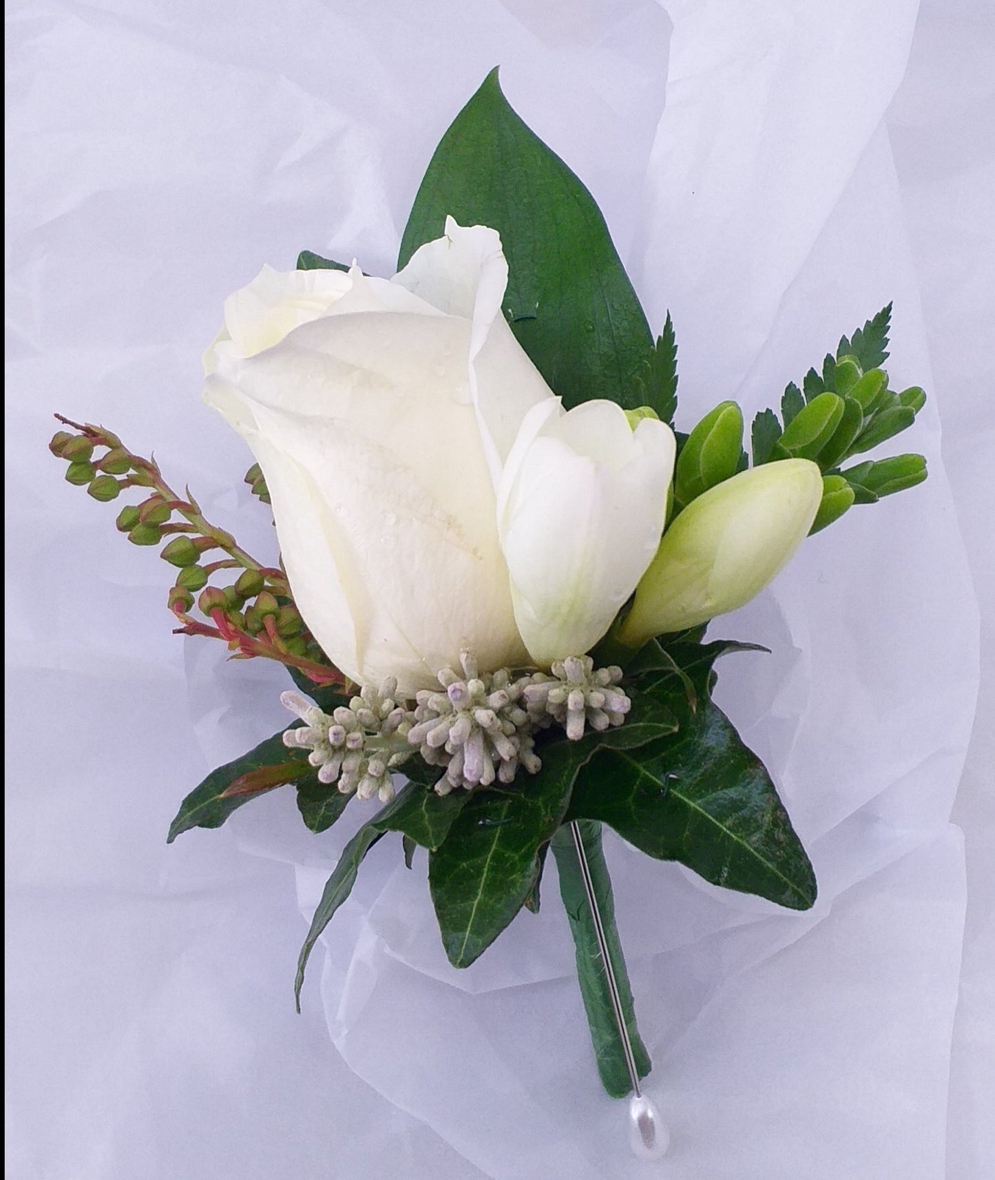 Buttonhole, white rose, small pieces of foliage, with leaves