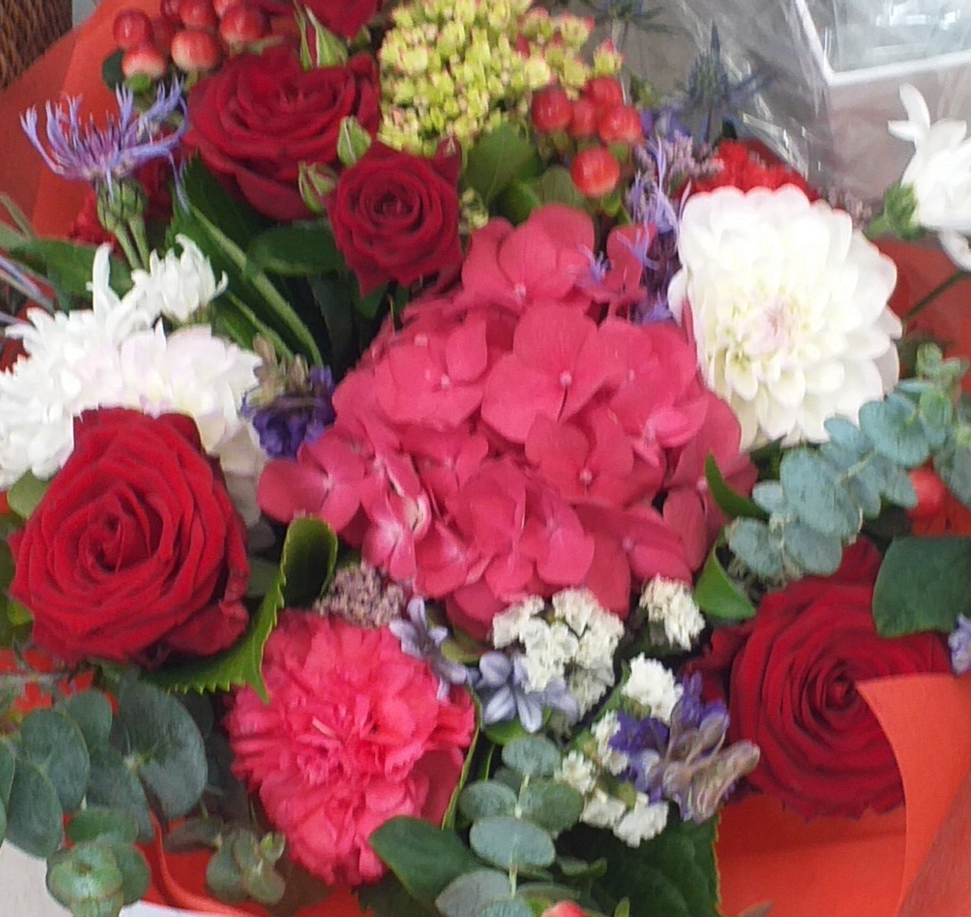 Flower bouquet in colours of red and white, carnation, roses, hydrangea (when in season) berries and gum