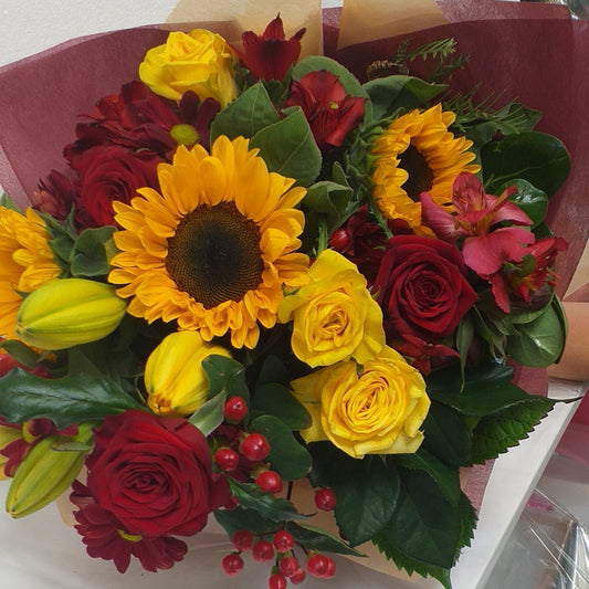 Red and gold bouquet of sunflowers, red and yellow roses and red alstromeria