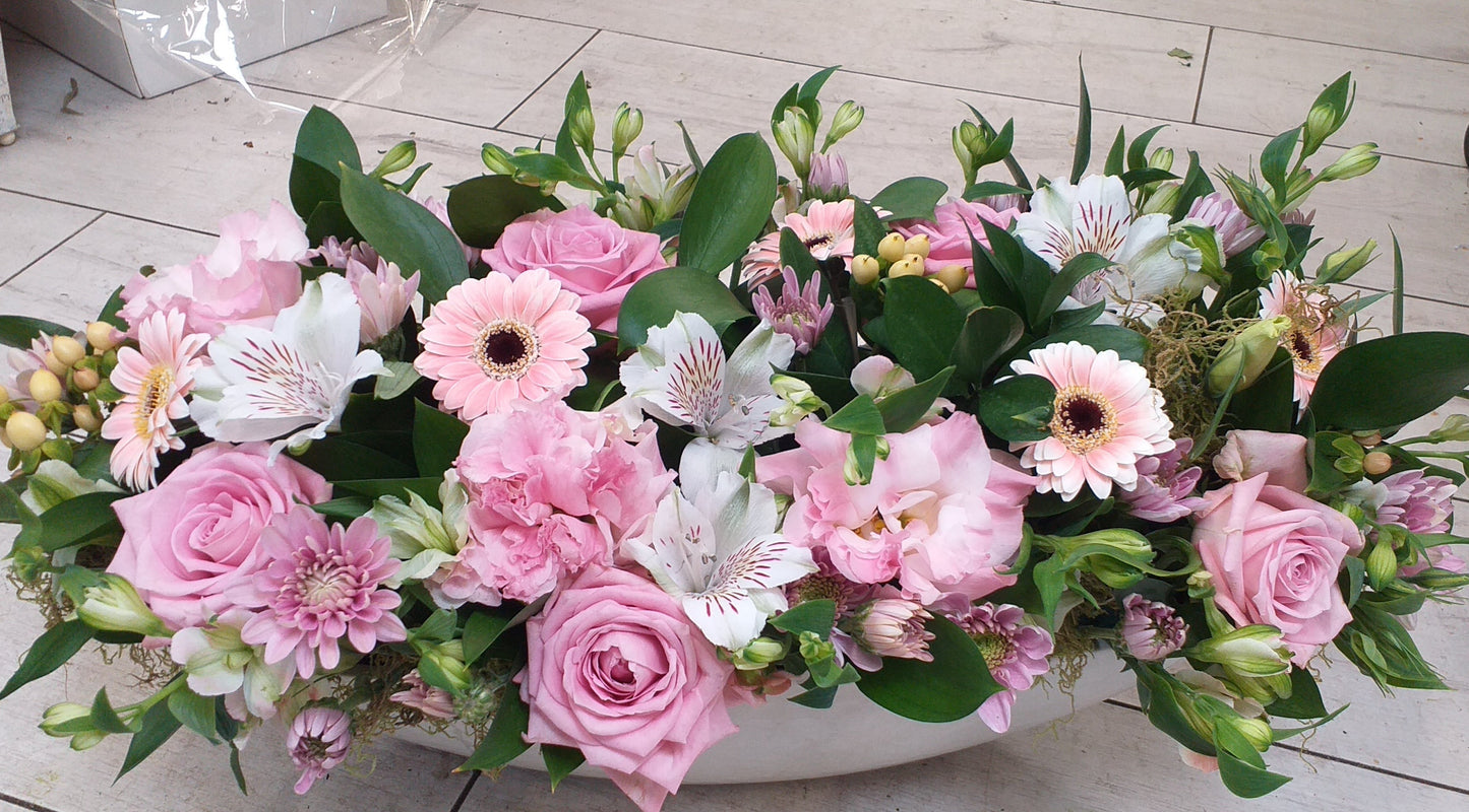 Trough arrangement, withpale pink roses, pale pink gerbera, white alstromeria, berries, spray chrysanthemums,. suitable for decorating a table, mantle piece, entrance table, display table.
